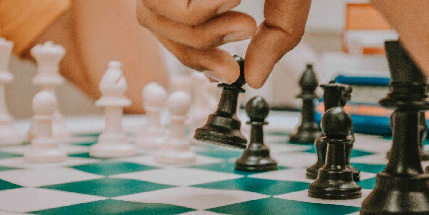 Una mano mueve un peón en un tablero de ajedrez